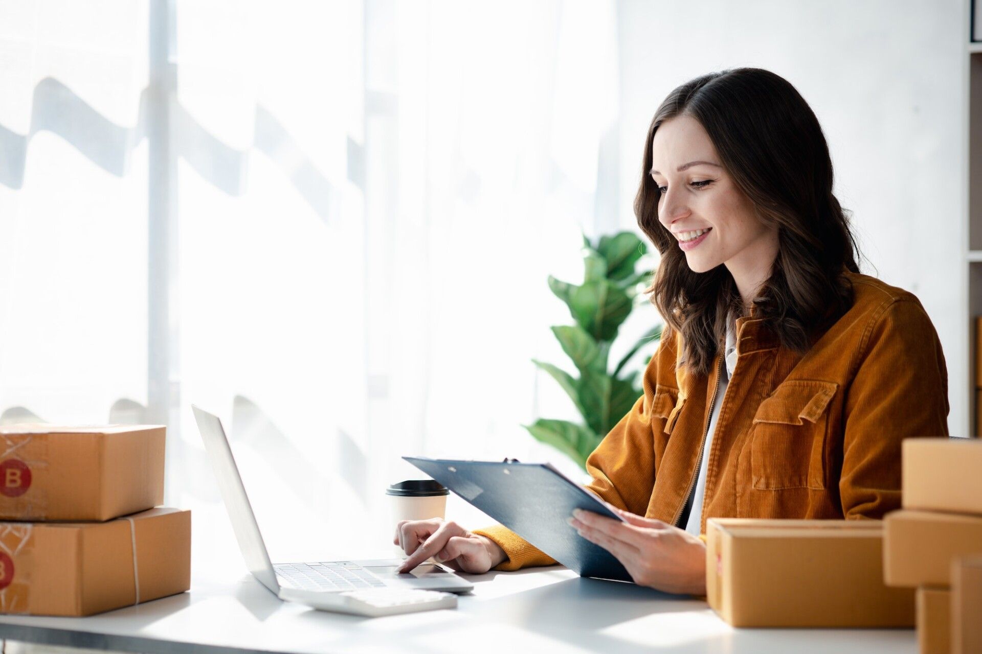 A beautiful business owner opens an online store, she is checking orders from customers, sending goo