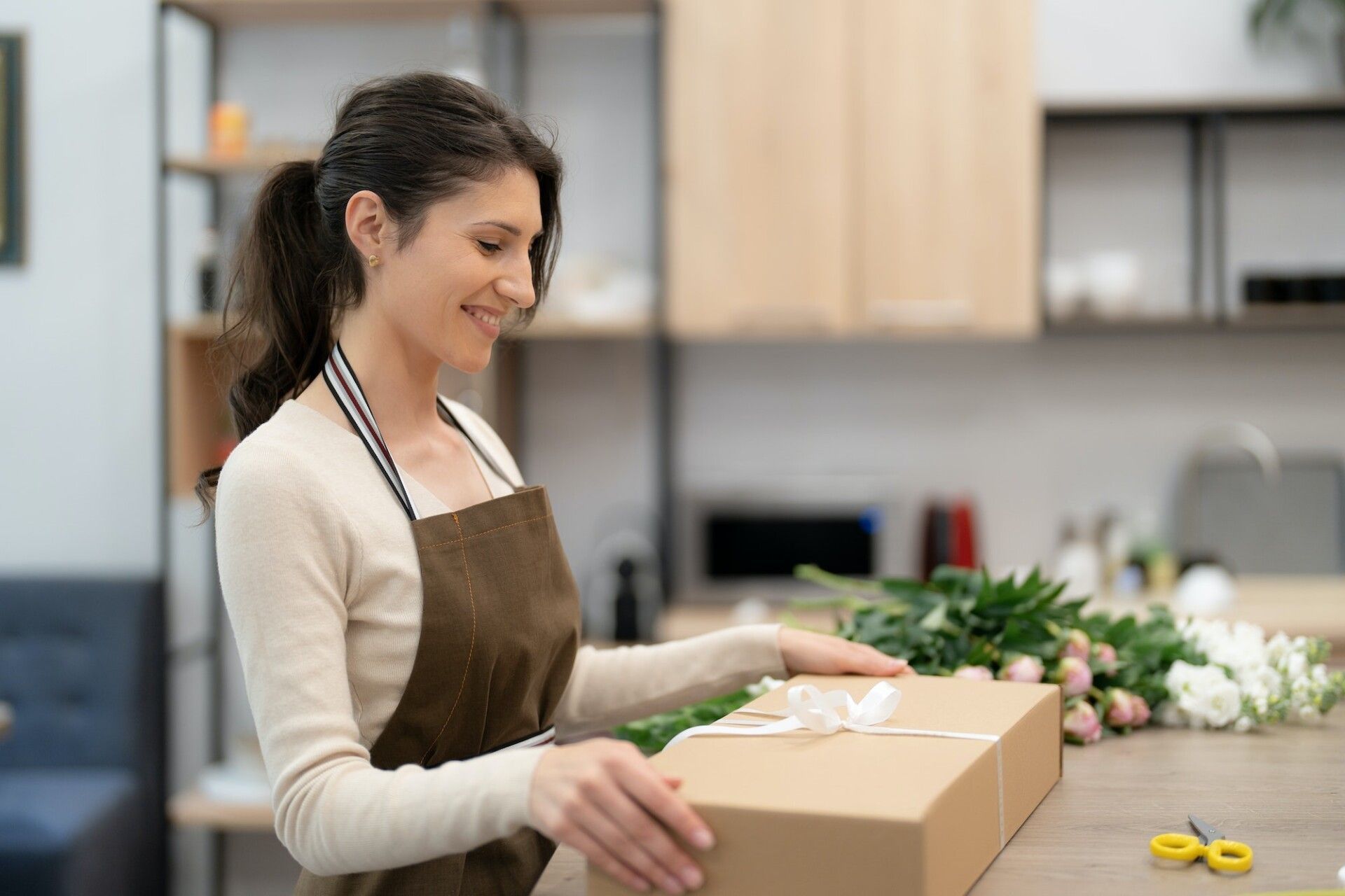 Florist working with flowers making a composition ghift box