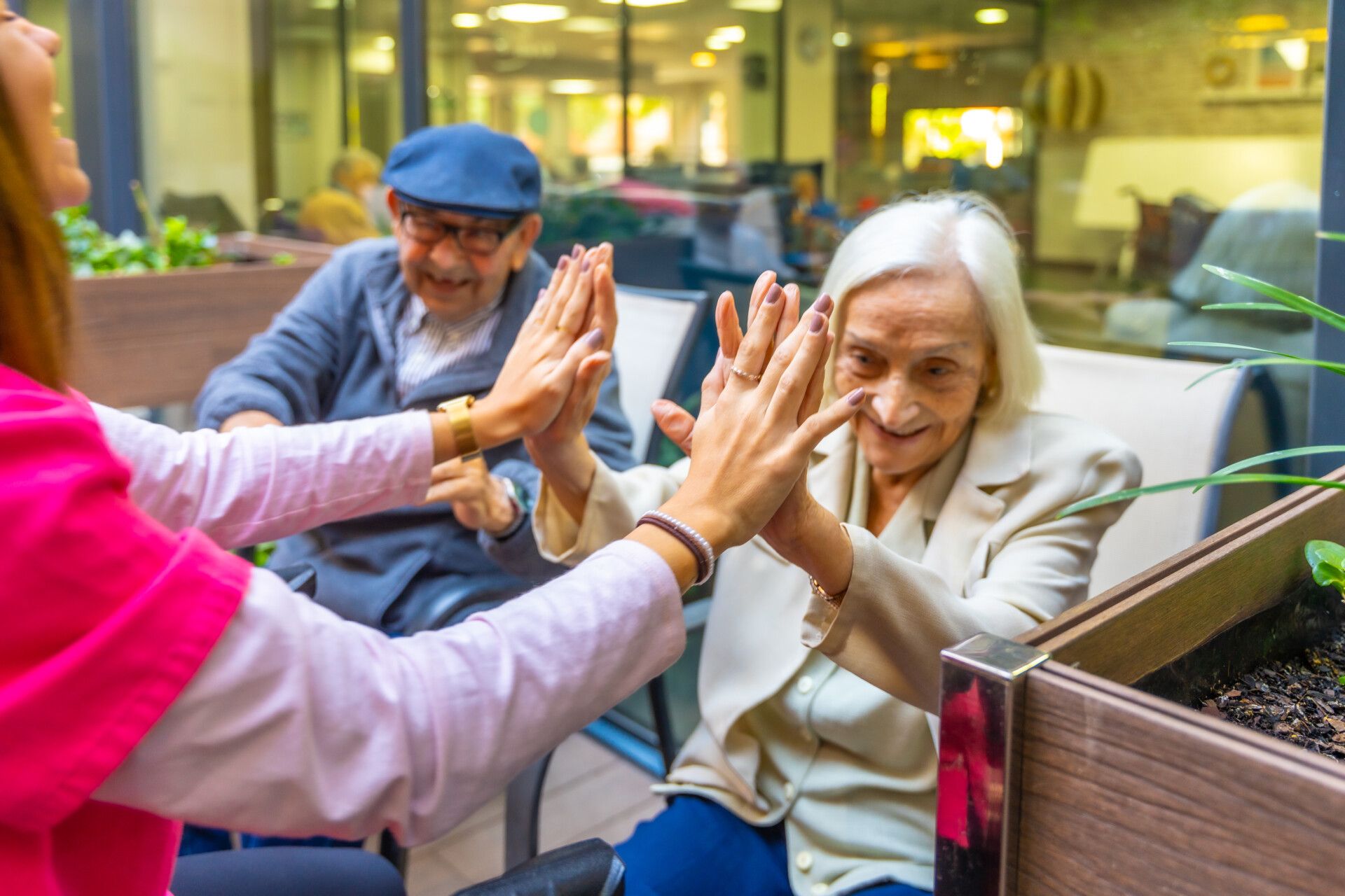 Playful cute nurse with elder people in a nursing home