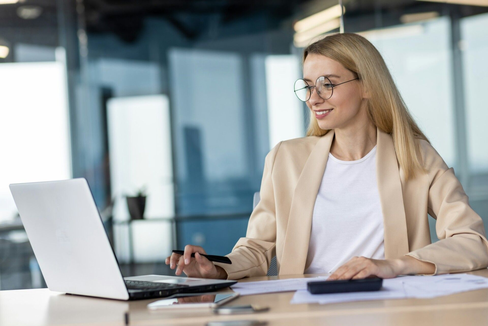Portrait of smiling young business woman, bank employee, manager working in office with documents