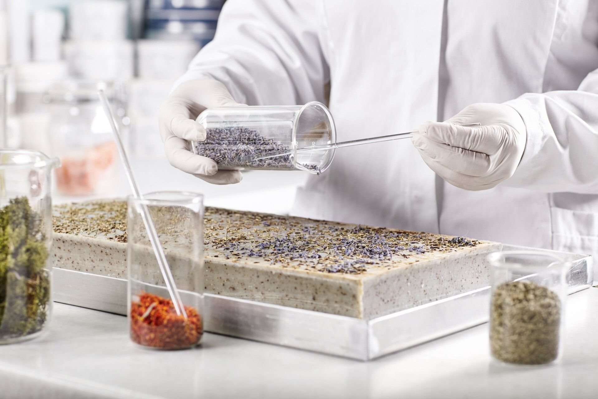 Life scientists researching in laboratory. Young researcher wearing white medical gloves and gown st