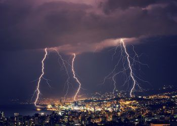 Beautiful lightning at night over gorgeous glowing Lebanon, majestic nighttime cityscape, stormy weather